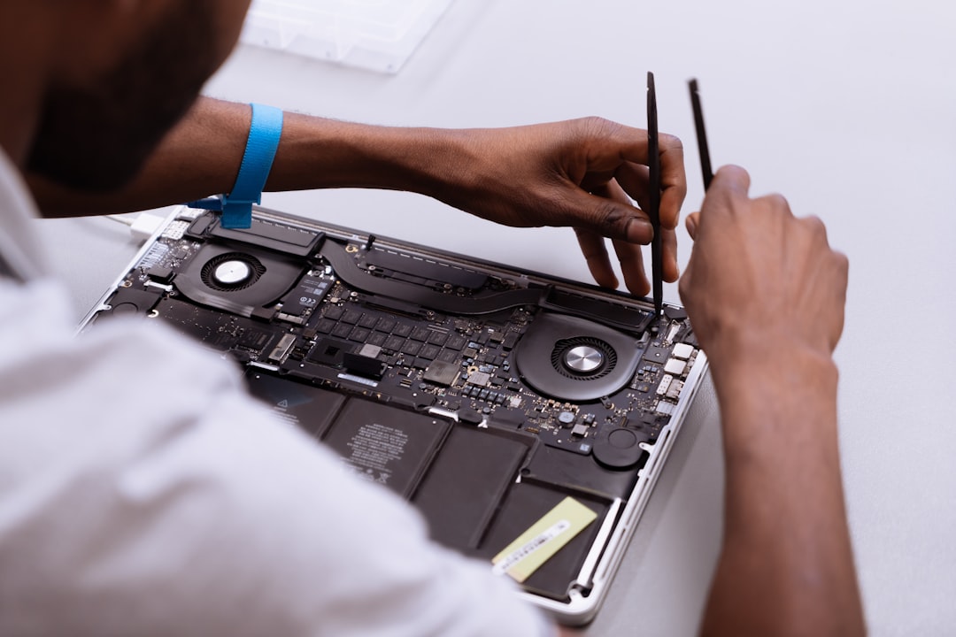 Technician repairing a laptop motherboard at a workshop bench, illustrating the right to repair electronics you own