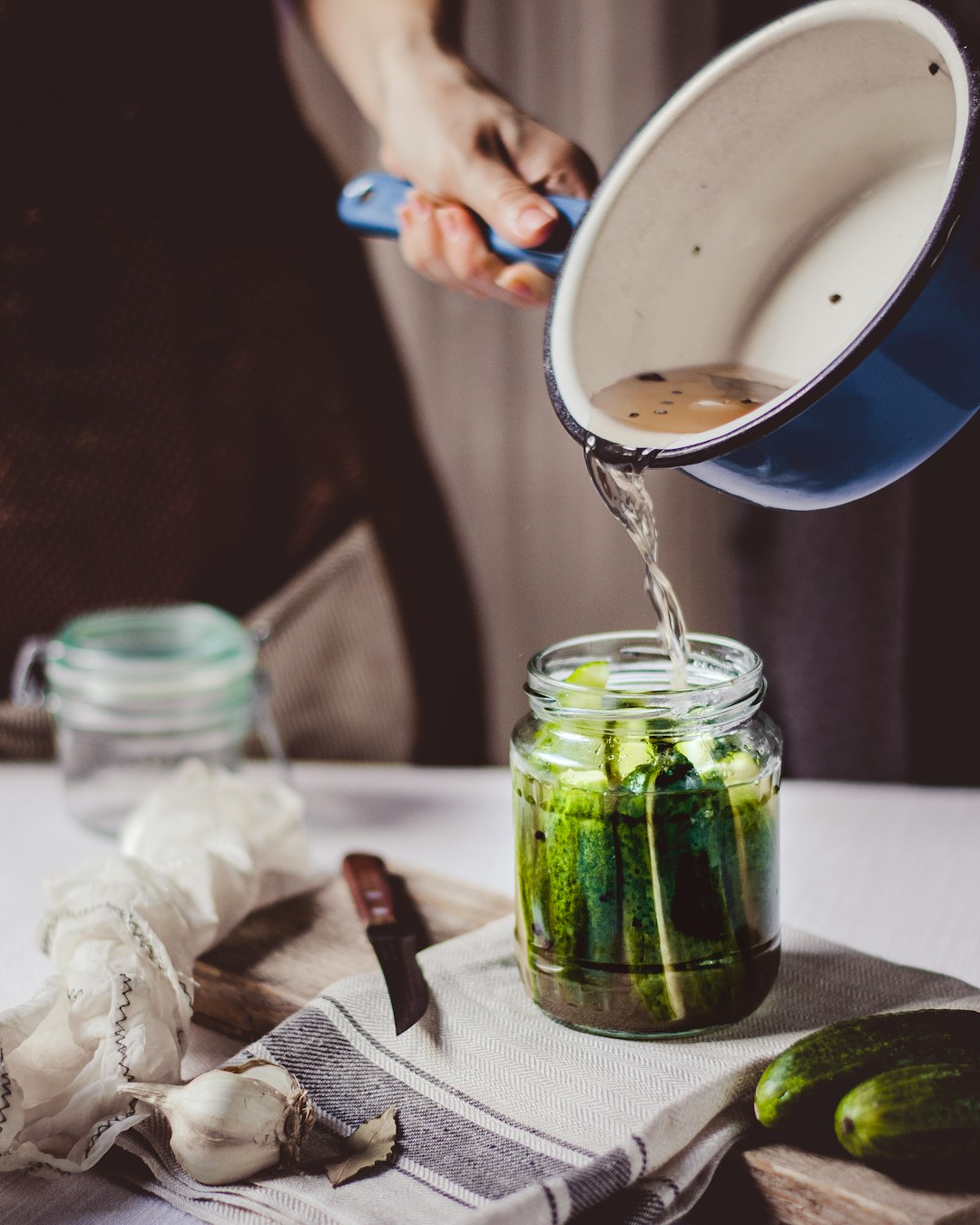 An open mason jar of bright green homemade sauerkraut on a wooden <a href=