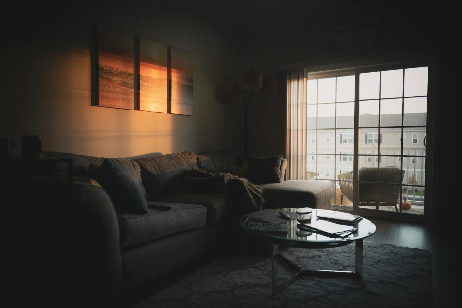 A dim, moody living room at night with soft light through a window