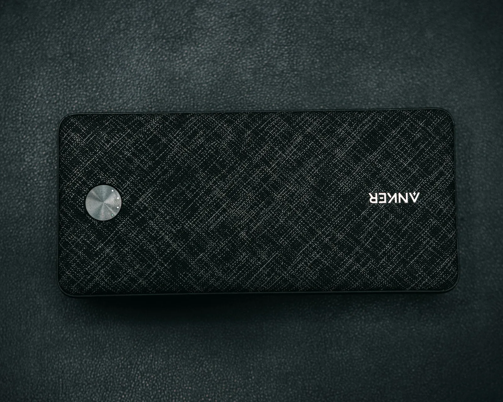 A compact portable battery pack on a dark surface, standing in for a small UPS unit