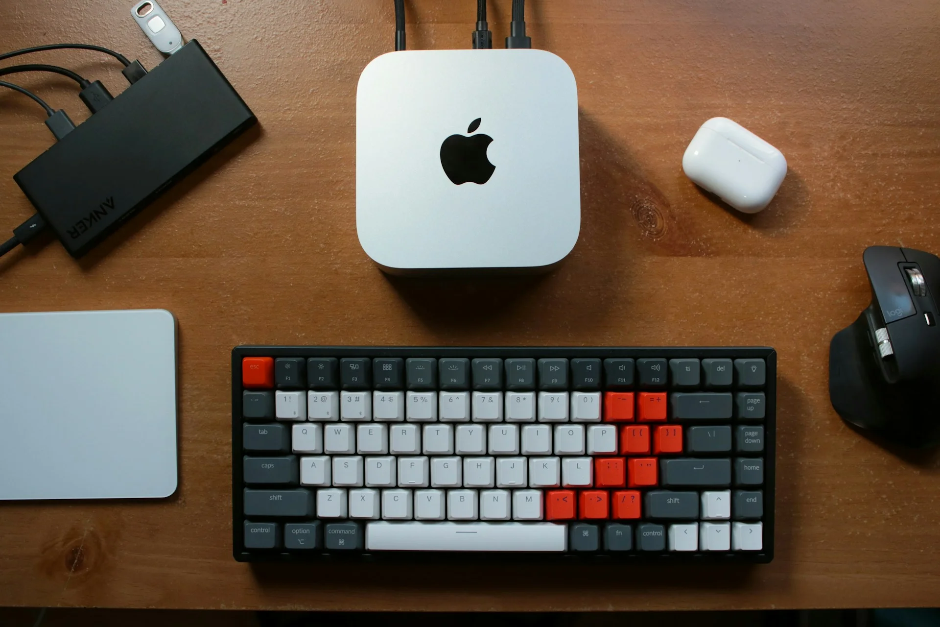A Mac mini on a wooden desk beside a keyboard, viewed from above