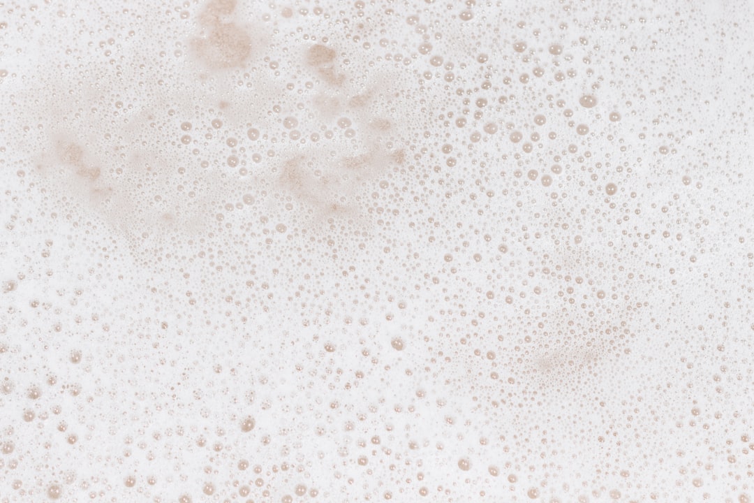 Close-up of CO2 bubbles forming on the surface of fermenting liquid in a glass jar